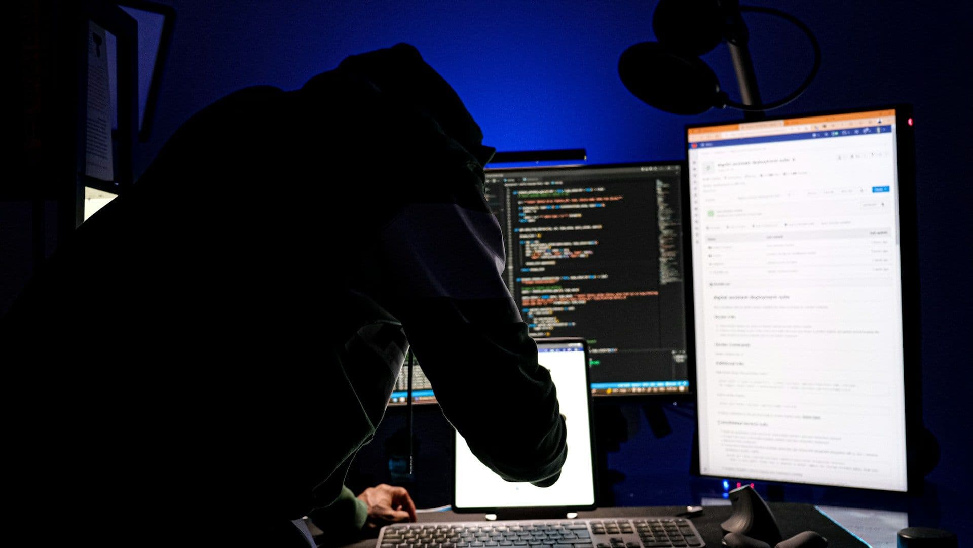 Hacker facing screens with lines of code (Boitumelo/Unsplash)